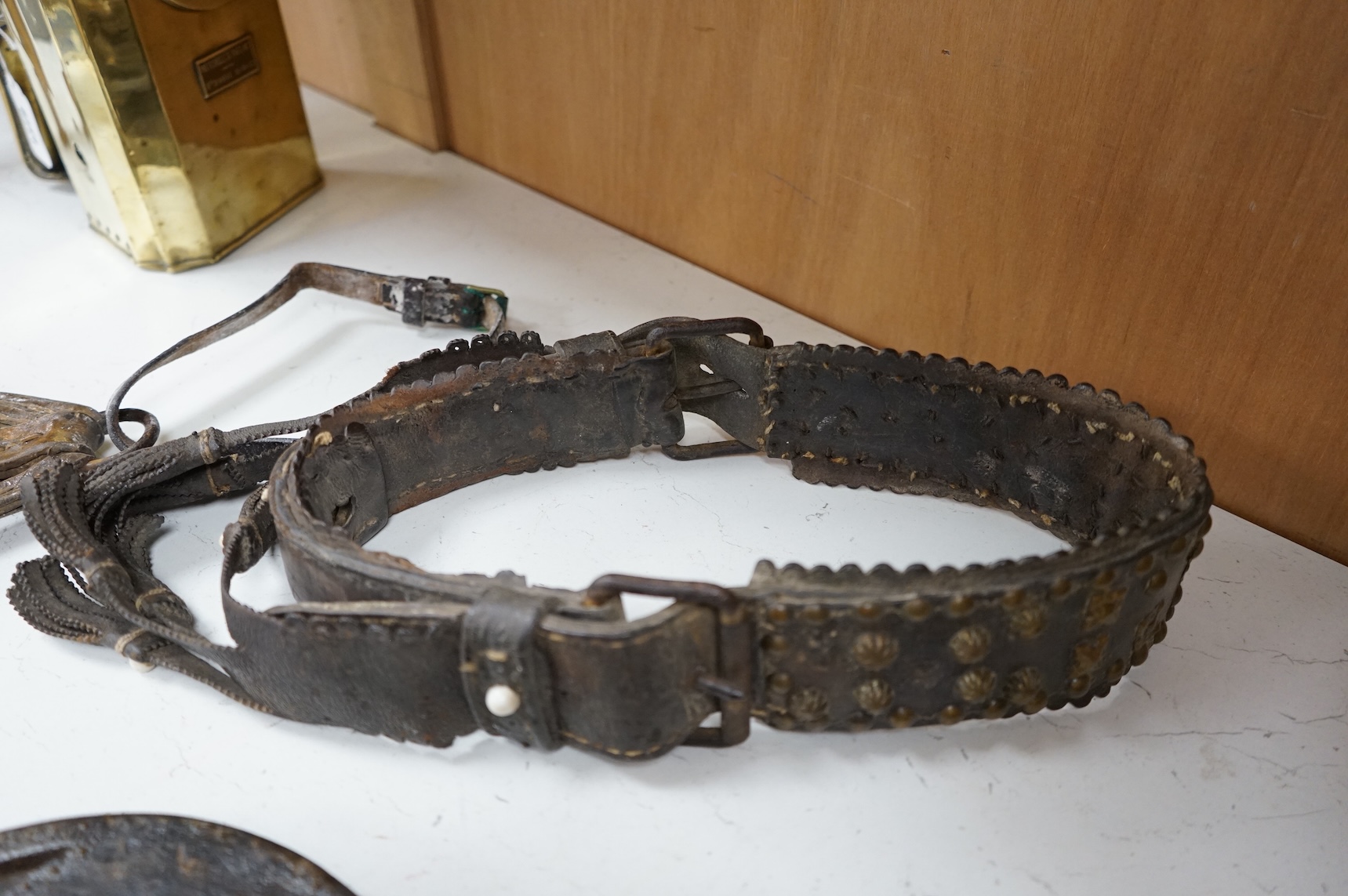 A pair of Argentinian Gaucho leather and piqué work stirrups together with a similar brass mounted belt